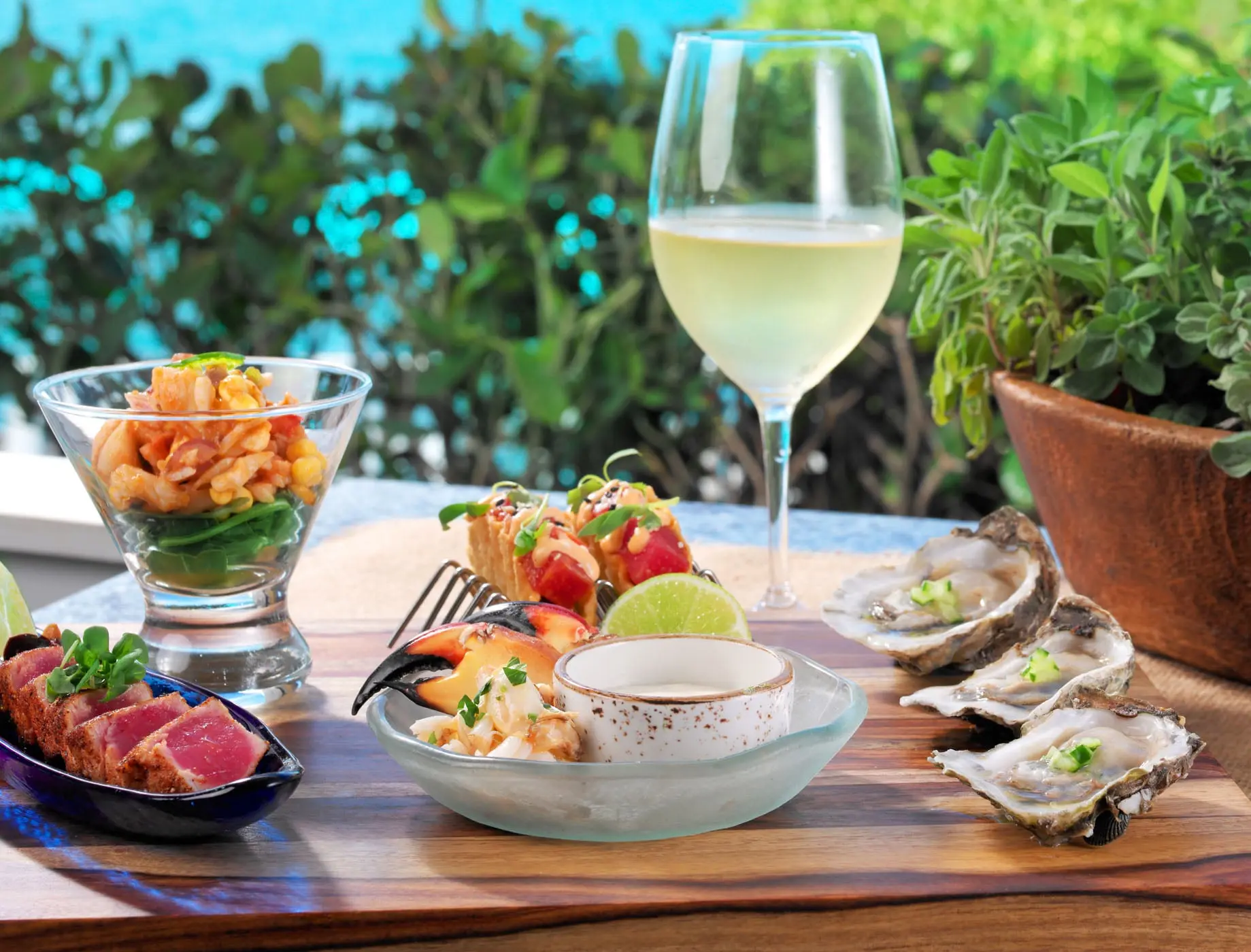 4 seafood dishes and a glass of white wine