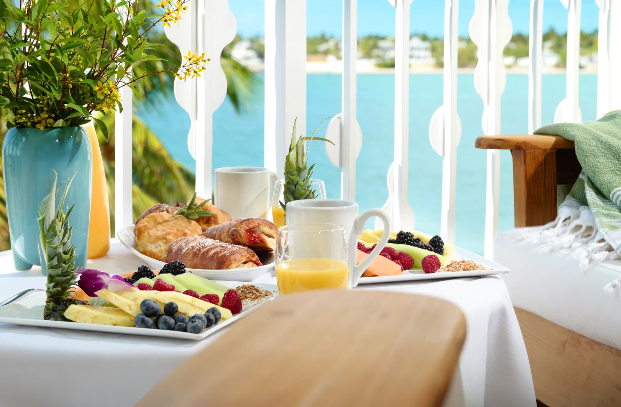 A table with a variety of fruits and pastries on a balcony off of a room at Ocean Key Resort